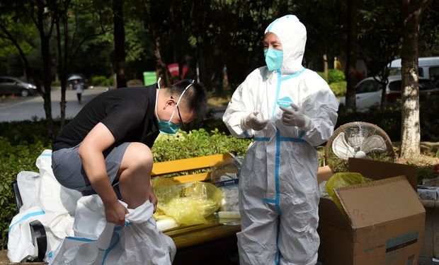 Un trabajador médico se pone un traje protector en medio de una prueba masiva por coronavirus en Wuhan, provincia de Hubei, China, el 4 de agosto de 2021. REUTERS / Stringer