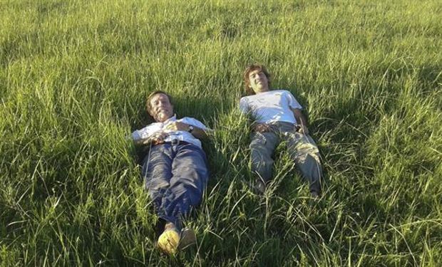 Padre e hijo sobre un colchón de pasto.