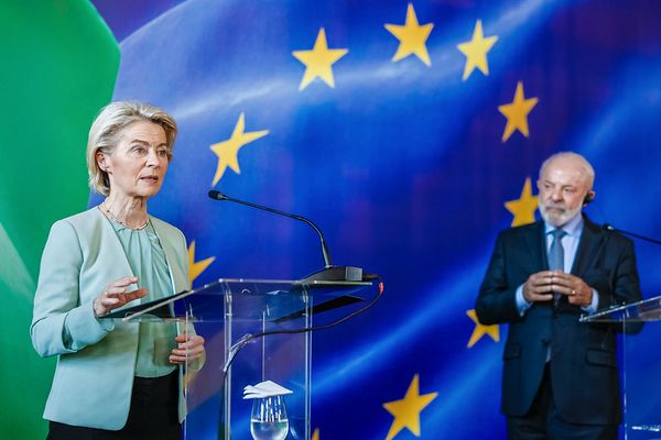 Autoridades da União Europeia e do Brasil durante coletiva sobre o acordo Mercosul-UE, com bandeiras europeias ao fundo