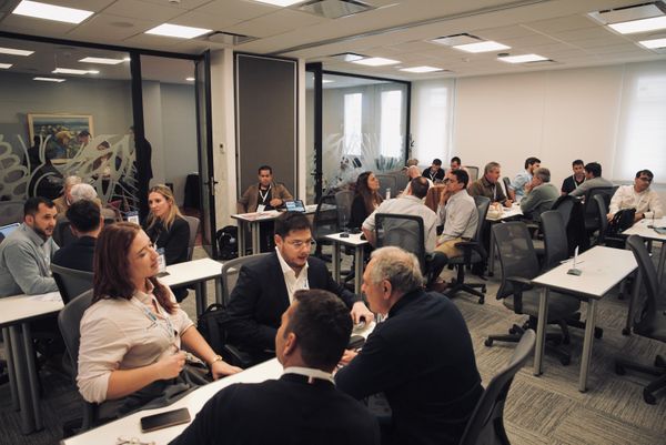 Reunión de trabajo con productores y funcionarios sentados en mesas, con documentos y computadoras, en un salón de reuniones