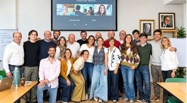 Primos de una familia agropecuaria reunidos en una sala, algunos conectados por videollamada