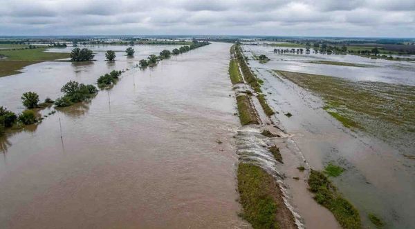 Vista aérea de campos inundados por excesos de lluvia, con agua cubriendo caminos rurales y lotes