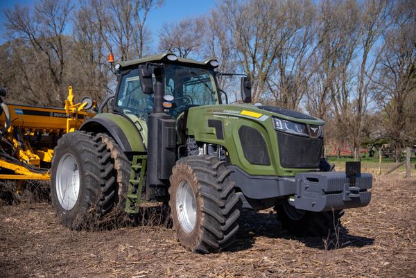 Tractor verde de 260 HP con cabina cerrada y dos ruedas delanteras y traseras de gran tamaño, en un campo con rastrojo.