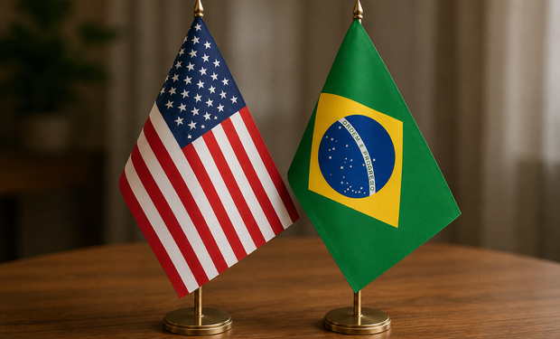 Bandeiras de Brasil e Estados Unidos posicionadas sobre uma mesa.
