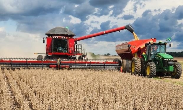 Colheitadeira realiza a colheita de soja e descarrega grãos em carreta durante operação em lavoura brasileira. A soja lidera o Valor Bruto da Produção Agropecuária (VBP).