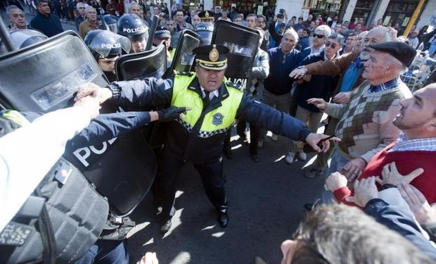 Un jefe de la Policía separa a sus subordinados y a los productores con sus brazos, en uno de los momentos tensos de la protesta del campo.