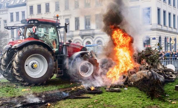 Manifestantes queimam pneus durante um protesto de agricultores europeus em frente ao local da Cúpula da UE em Bruxelas. (Foto - Marius Burgelman/AP)